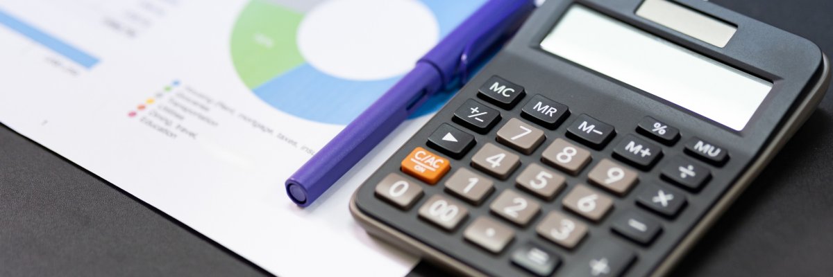 Grafiken, Stift und Taschenrechner auf einem Tisch