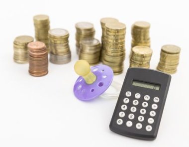 Schnuller mit hartem Geld und Taschenrechner Schnuller mit hartem Geld und kleinem Taschenrechner auf hellem Hintergrund