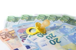 verschiedene Geldscheine mit einem gelben Schnuller