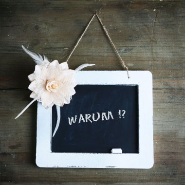 Verlust Holzwand mit weißer Tafel und Blumenornament, Aufschrift warum
