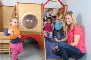 spielende Kinder mit Betreuerin