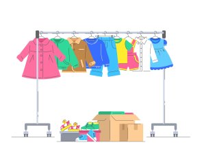 Verschieden Kinderkleidung, die an einem rollenden Kleiderbügel hängt. Kästen mit kleinen Schuhen und verschiedenen Sachen.