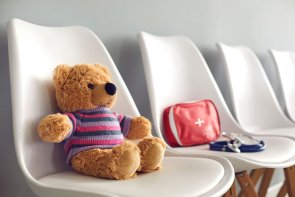 First-aid kit, stethoscope and cute teddy in waiting room of children's medical center