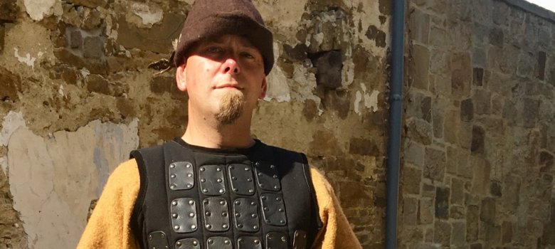 Mann altes Kostüm vor Gebäude