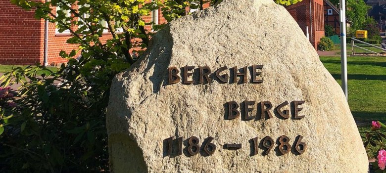 Stein mit Ortsschriftzug im Grünen