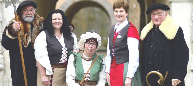 kleine Gruppe in historischen Kostümen vor altem Gebäude